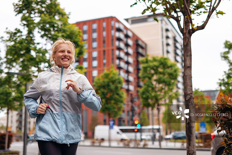 年轻女性在阴天的城市中慢跑图片素材