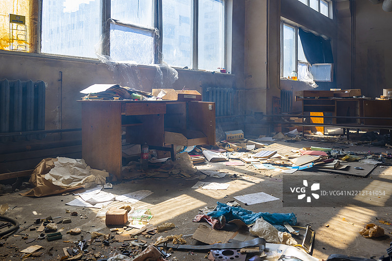 废弃的房间里充满了杂物和灰尘，阳光透过肮脏的窗户洒进来。图片素材