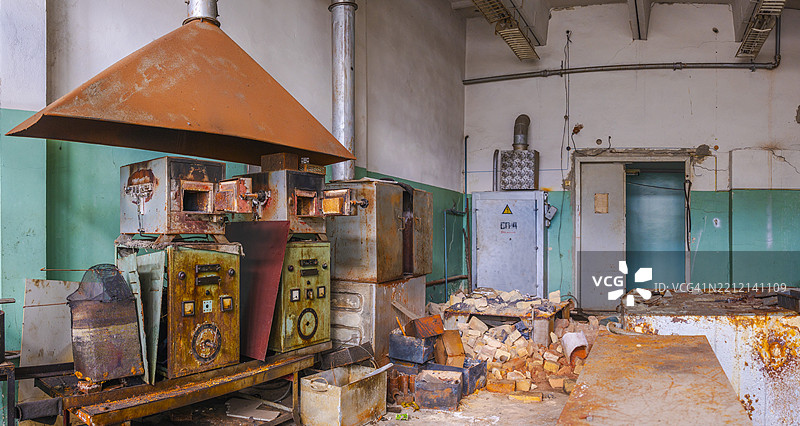 废弃工厂内的旧工业厨房，生锈的设备和杂物散落一地图片素材
