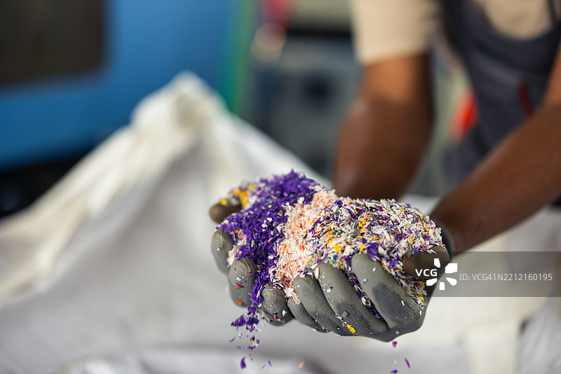 回收厂员工双手托着塑料颗粒原料图片素材