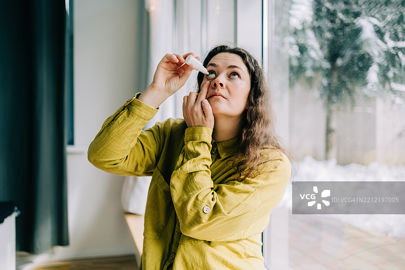 冬季时在家中使用眼药水的女性图片素材