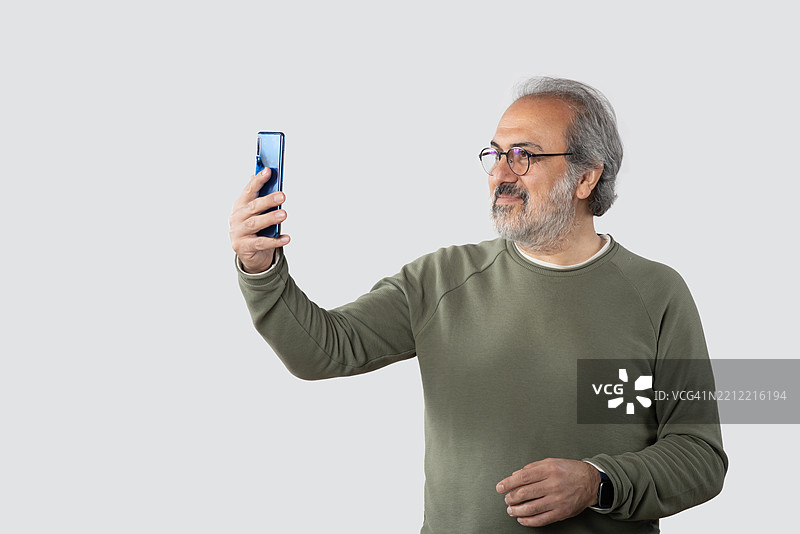 留胡子的男人肖像，手持智能手机。图片素材