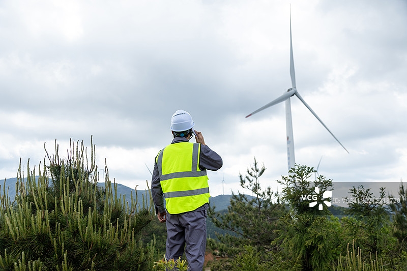 微笑的电气工程师在风电站工作图片素材