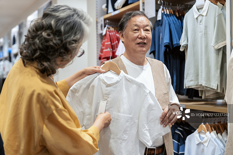 亚洲老年夫妇在服装店挑选新衣服。图片素材