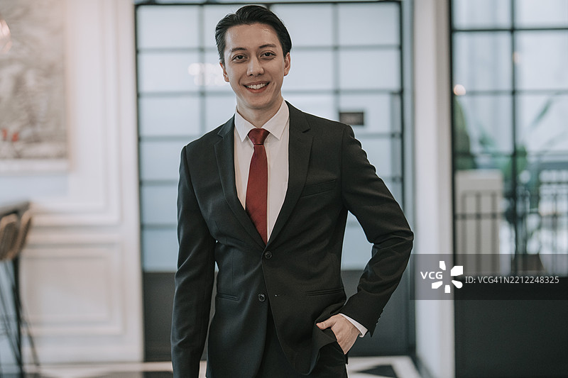 友好的亚洲商人在现代办公室内微笑图片素材
