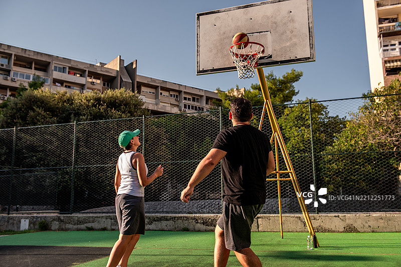 篮球运动员在户外球场投篮图片素材