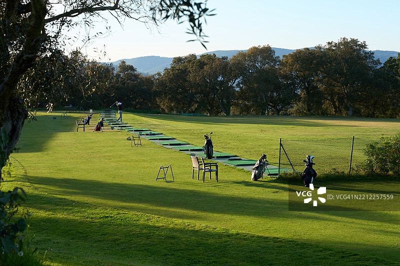 高尔夫球手在阳光明媚的日子里练习挥杆。图片素材