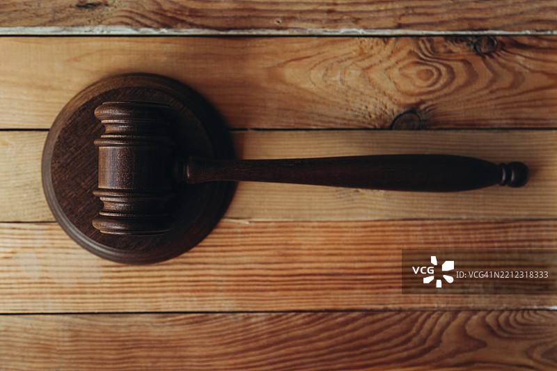 棕色法槌放在圆形音响块和木桌上。图片素材