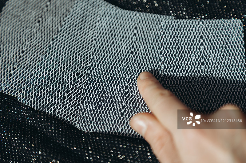 女性手指向躺在黑色闪光布上的一张卡片。图片素材