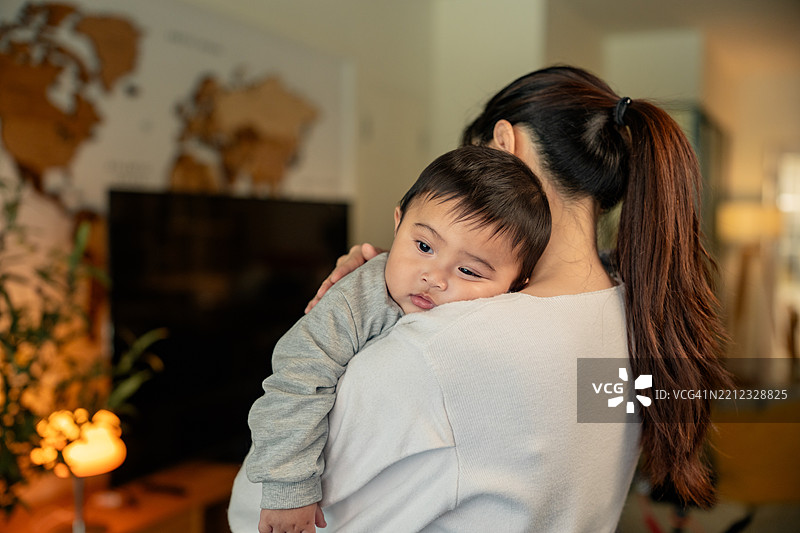 年轻单身母亲在家中拥抱她的小儿子（婴儿/幼儿）图片素材