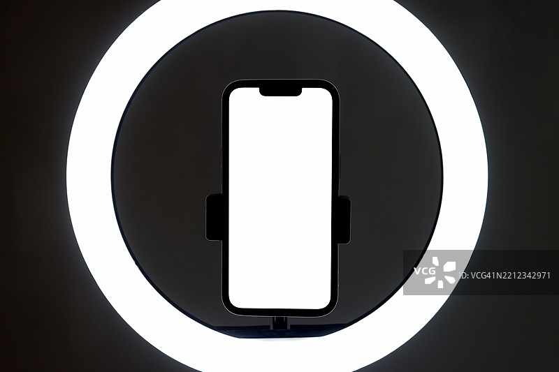 提升您的手机摄影水平，使用我们高质量的图像，展示一部连接到环形灯的手机。非常适合拍摄专业外观的自拍、产品照片等。图片素材