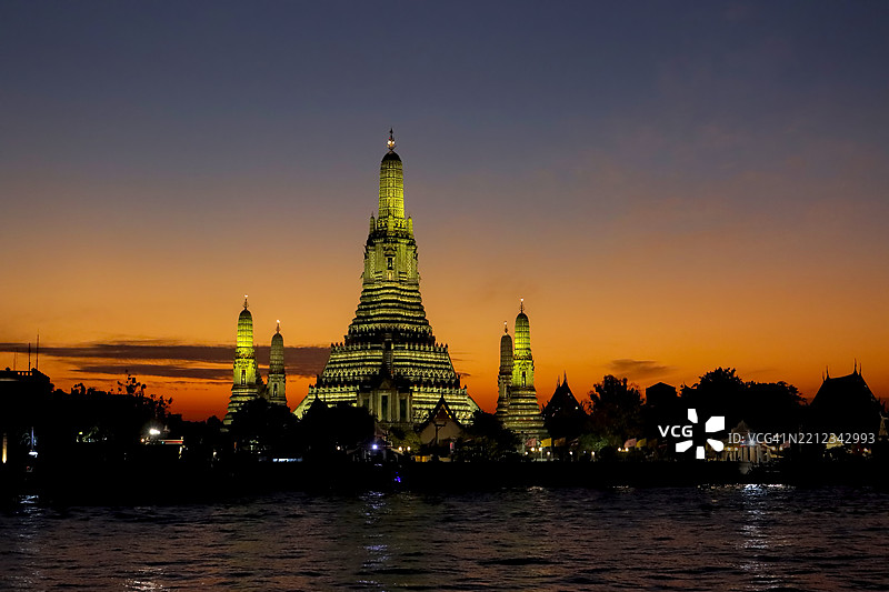 泰国曼谷湄南河上的阿伦寺在日落时分的灯光照耀下图片素材