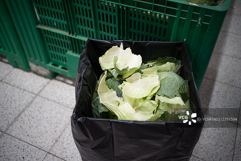 白菜叶被丢弃在黑色塑料袋中图片素材