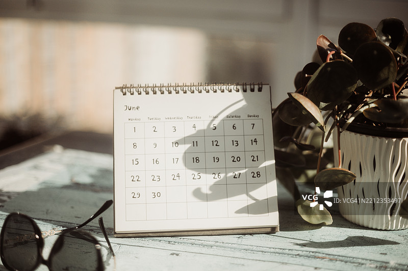 六月日历、便签本和咖啡杯。图片素材