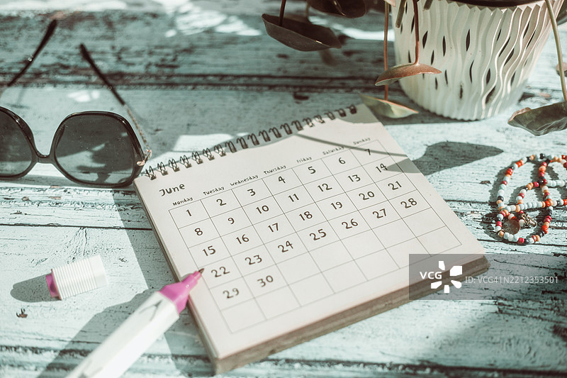 六月日历、便签本和咖啡杯。图片素材
