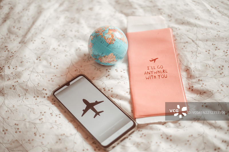 手机显示飞机订票应用和护照图片素材