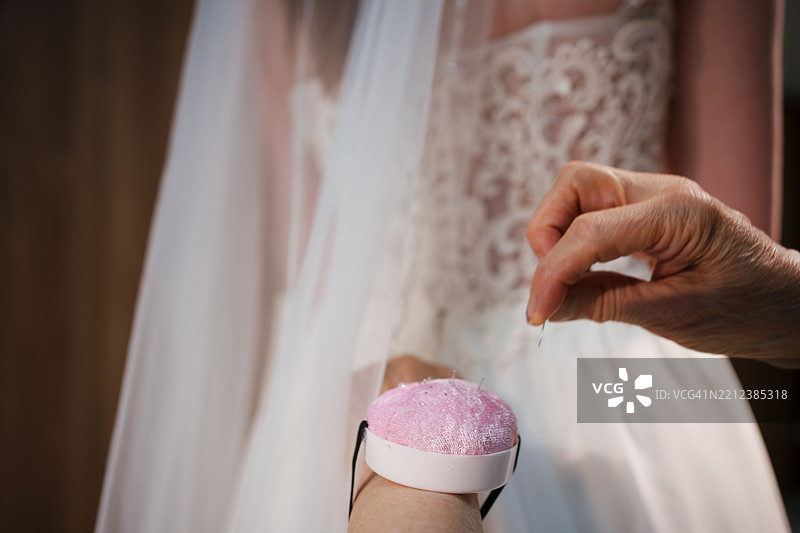 裁缝在婚纱店为新娘测量腰围以进行婚纱试穿图片素材