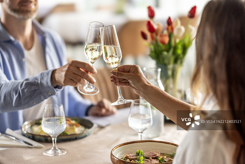 一对恋人正在餐厅享受浪漫晚餐，举杯庆祝香槟或普罗塞克 - 特写镜头图片素材