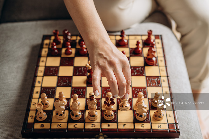 一位女性在下棋，一只女性的手在棋盘上放置和移动棋子，爱好，策略图片素材