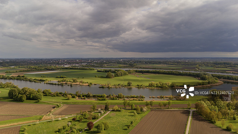多瑙河流经广阔的田野和云朵，背景中有一个小镇，斯特劳宾，巴伐利亚州下部，德国，欧洲图片素材