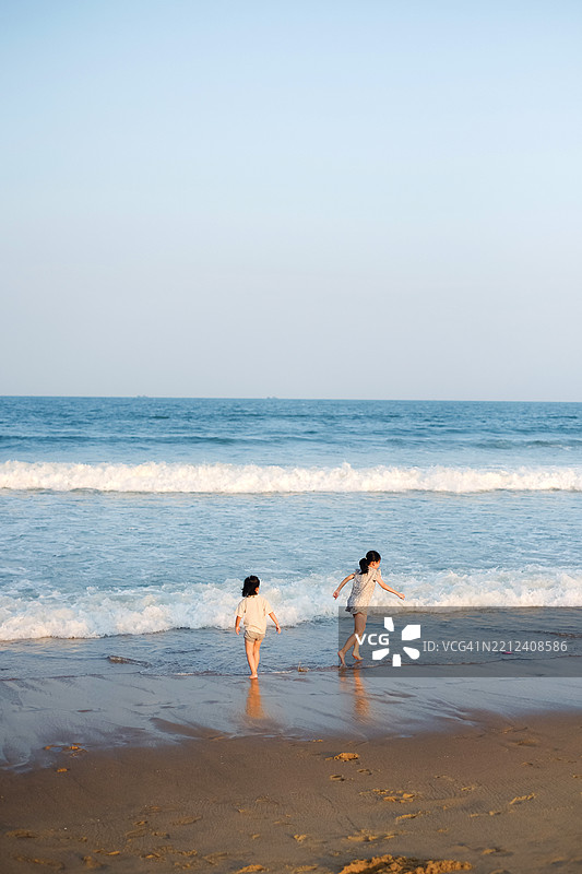 姐妹们在海滩上。图片素材