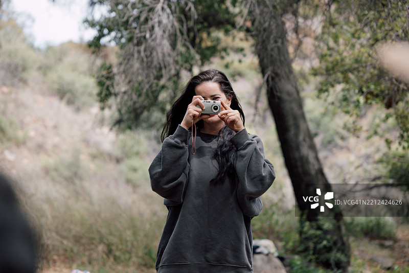 女性使用2000年代初期的数码便携相机图片素材
