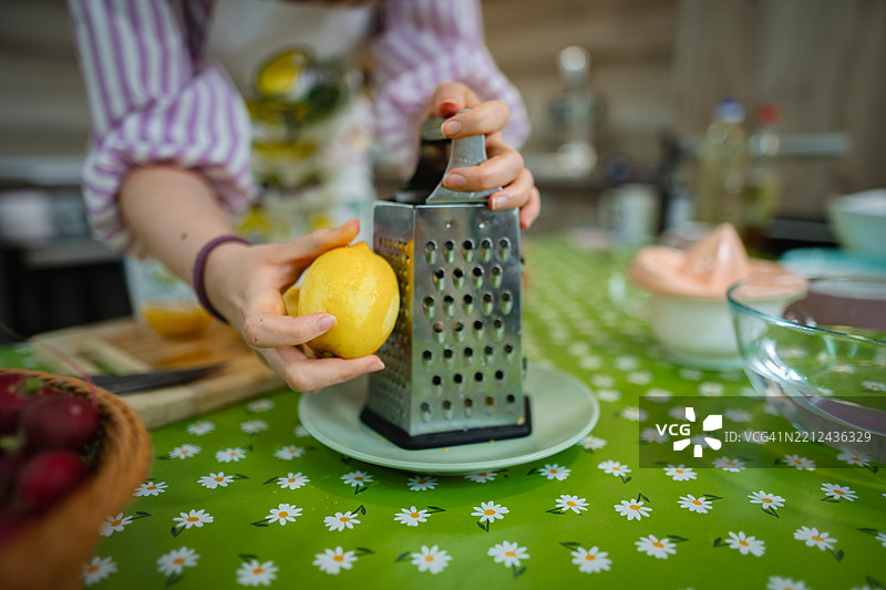 女人在厨房里擦柠檬皮屑图片素材