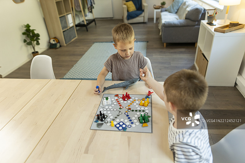幼儿在厨房桌子上玩飞行棋游戏图片素材