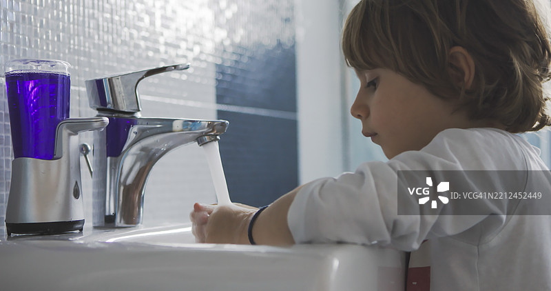 孩子在五彩水龙头旁洗手图片素材