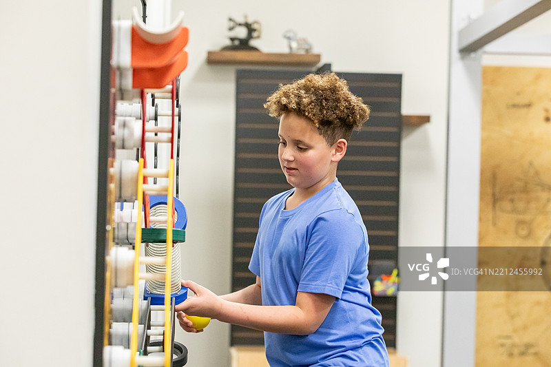 男孩在现代教室中使用STEM玩具探索工程理念图片素材