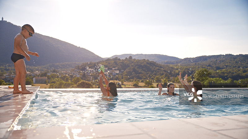孩子们在阳光明媚的泳池边享受美好的山景日子图片素材