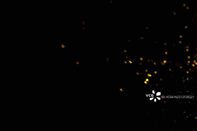 黑色背景上的金色散景灯光。闪烁的星星光斑叠加效果。图片素材