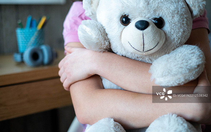 女孩紧紧拥抱着泰迪熊图片素材