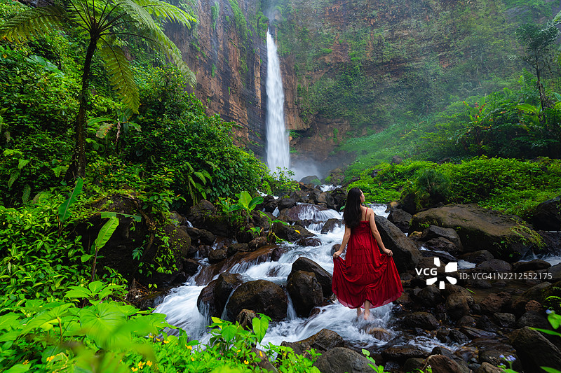 在印度尼西亚东爪哇的卡帕斯比鲁瀑布穿红色裙子的女性肖像图片素材