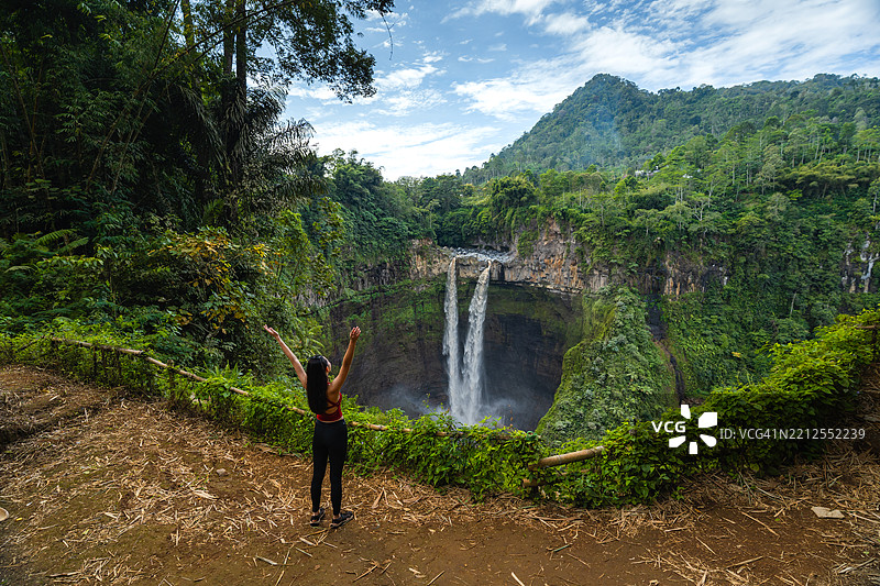 一位女性在印度尼西亚东爪哇省的科班斯里提瀑布旅行图片素材