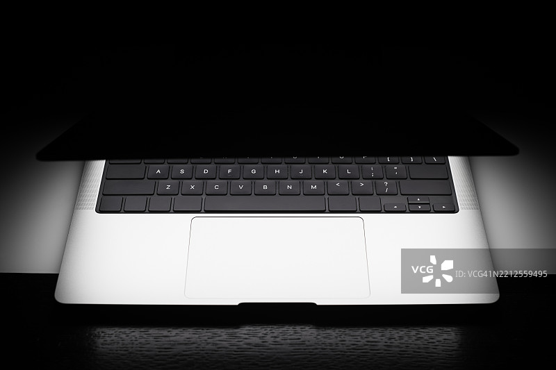 黑色背景上的发光现代笔记本电脑图片素材