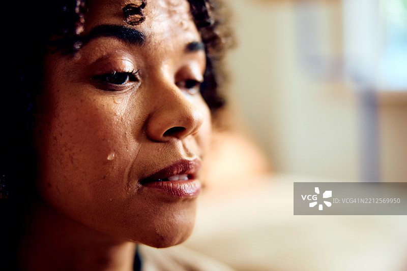 年轻女性脸颊上泪水滑落，特写镜头图片素材