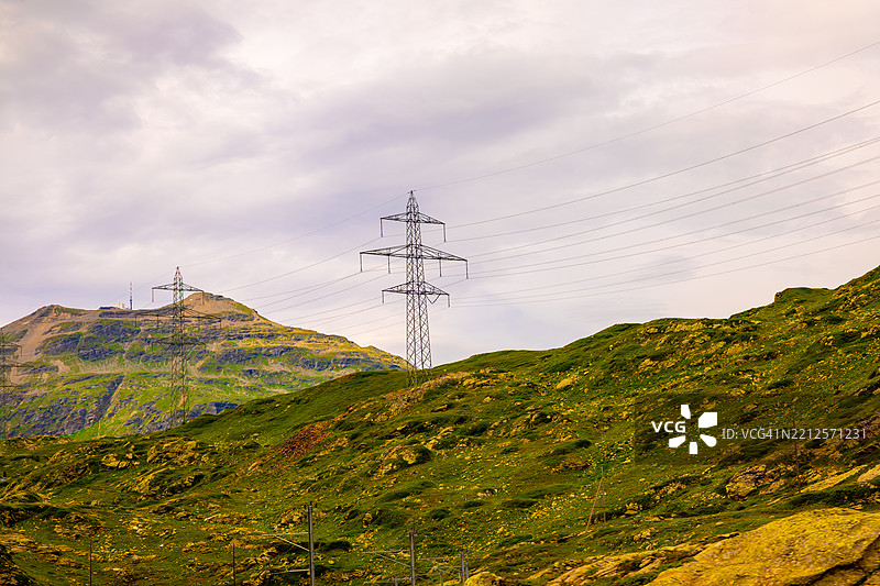 伯尔尼纳阳光明媚的夏日，瑞士阿尔卑斯山的电力塔与山景图片素材