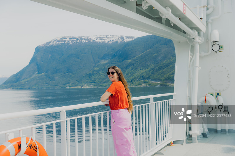 愉快的女性思考夏季旅行，乘渡轮穿越峡湾图片素材