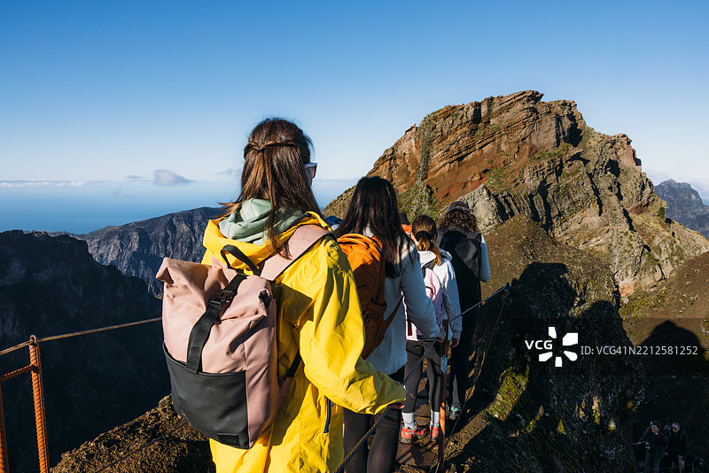 朋友们在壮丽的山脉中一起徒步旅行图片素材