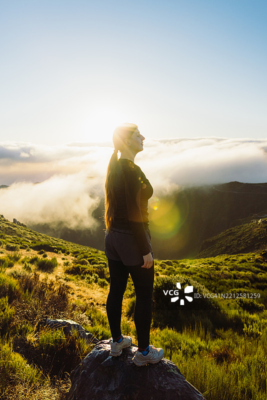 活力四射的女性欣赏皮库阿里埃罗山峰上壮丽的日出图片素材