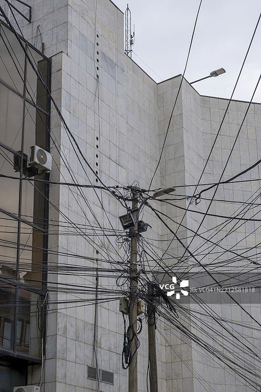 科索沃普里兹伦，巴尔干地区，欧洲：杂乱无章的电力和电信电缆安装在一根电线杆上图片素材