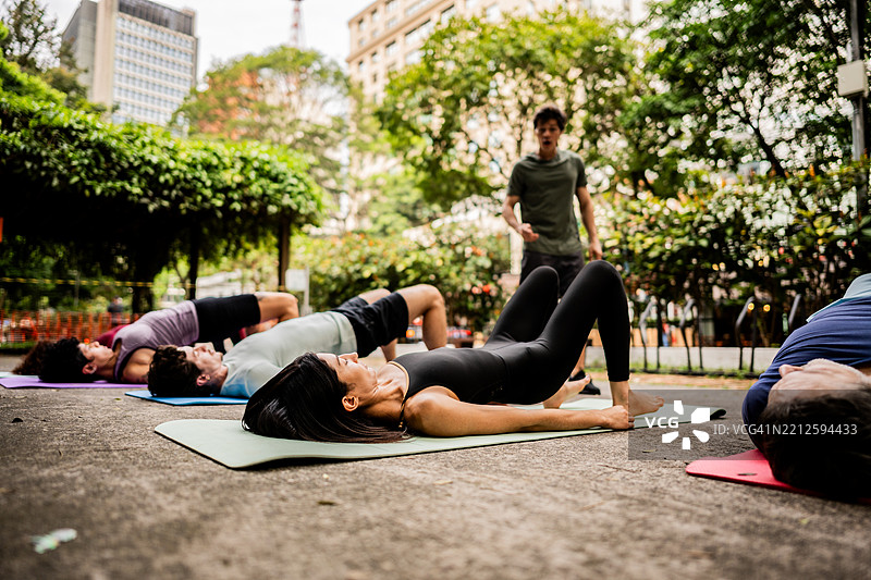人们在公园的课堂上伸展身体图片素材