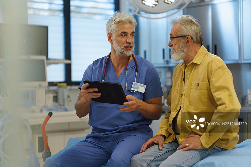 医生与老年患者交谈，向他展示平板电脑上的医疗结果。图片素材