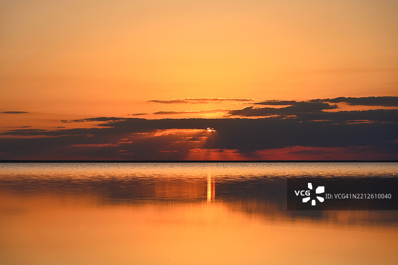 红色的太阳藏在埃尔顿湖上方的云层后面图片素材
