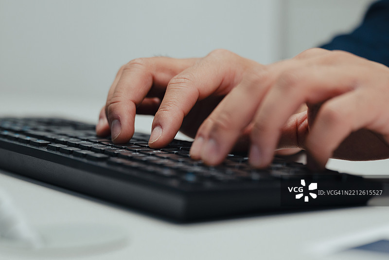 商人正在电脑上工作，敲击键盘。图片素材