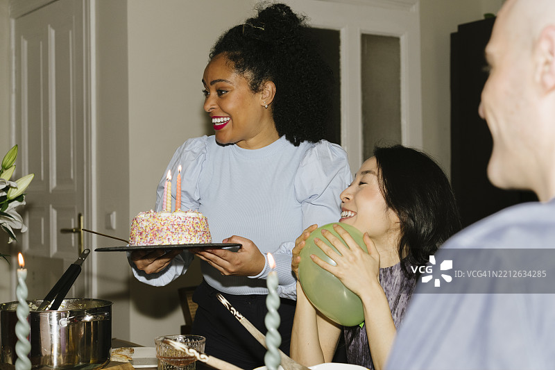 三个人，其中一个人手里拿着蛋糕图片素材