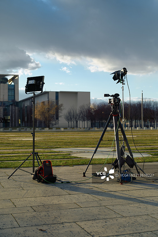 柏林，德国的户外视频制作设置，配备三脚架和照明设备，位于铺砌的地面上。图片素材