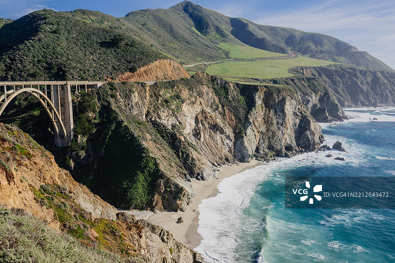 壮丽的海岸景观，绿意盎然的山丘、岩石悬崖，以及横跨海洋的美丽比克斯比溪桥。美国，加利福尼亚州图片素材