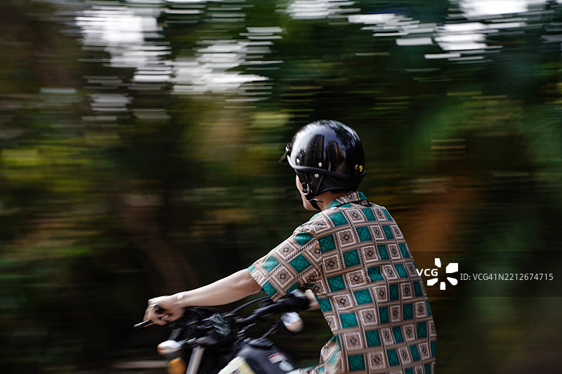 男孩在路上骑摩托车图片素材